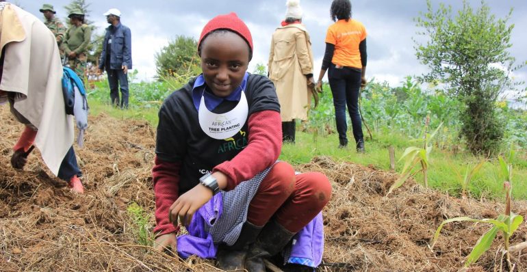 A Photo of a primary school girl planting a tree